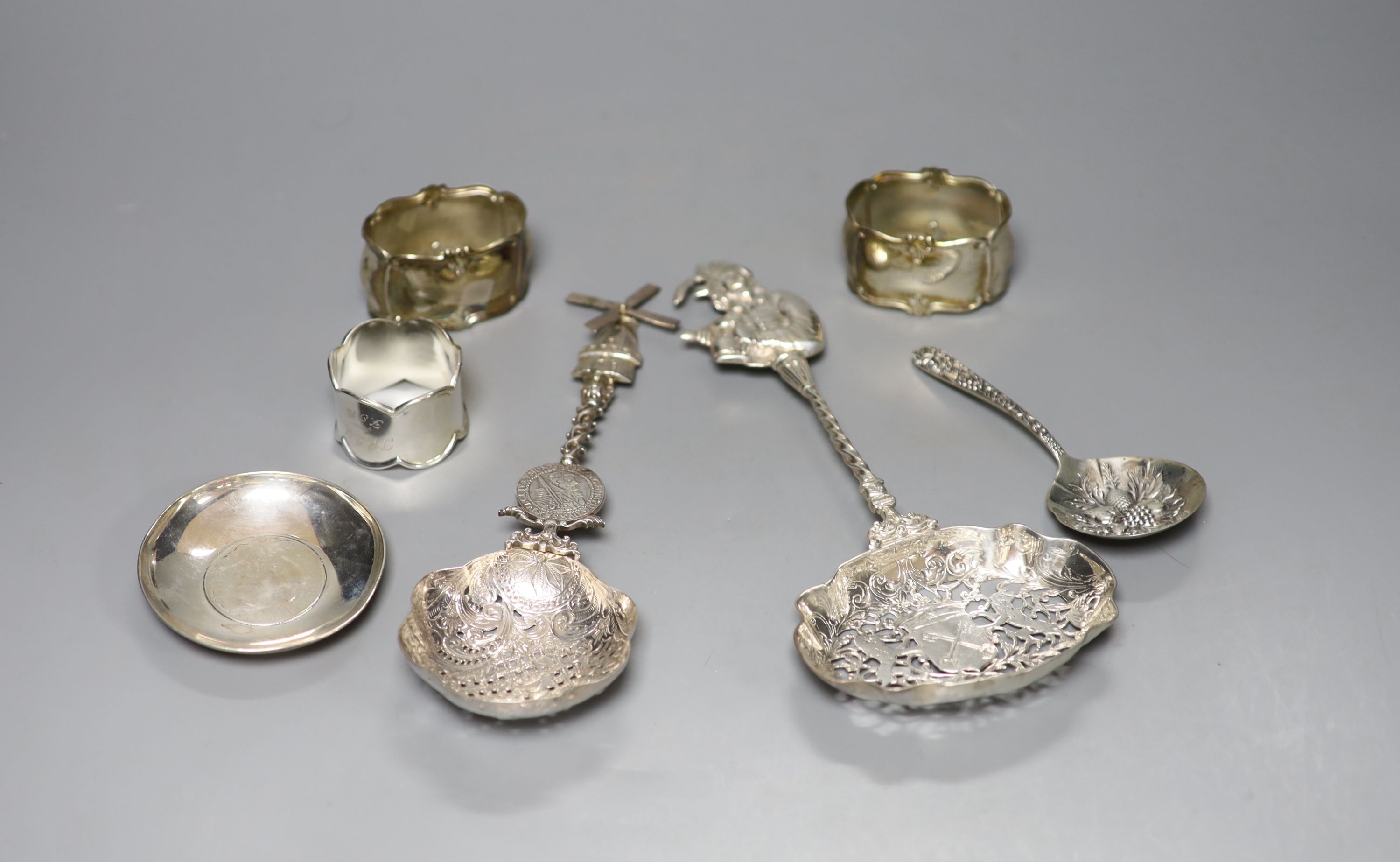 Two late 19th/early 20th century ornate pierced silver spoons, largest 23.7cm, a silver dish, sterling spoon and three napkin rings